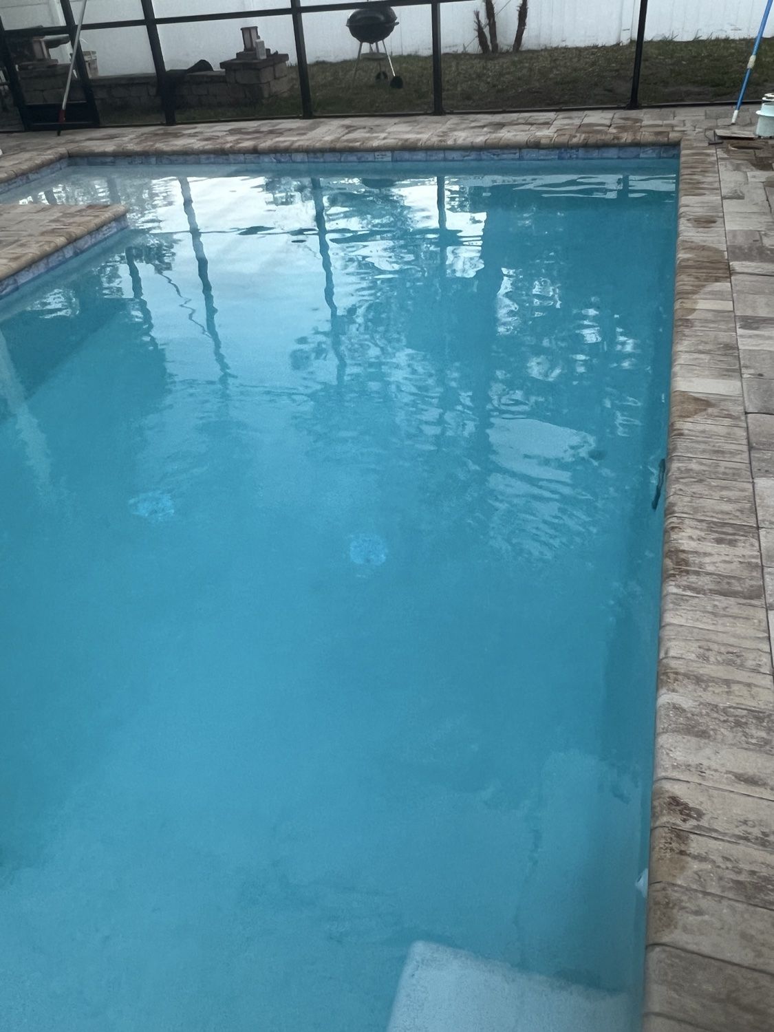 Finished residential pool with calm crystal-clear blue water