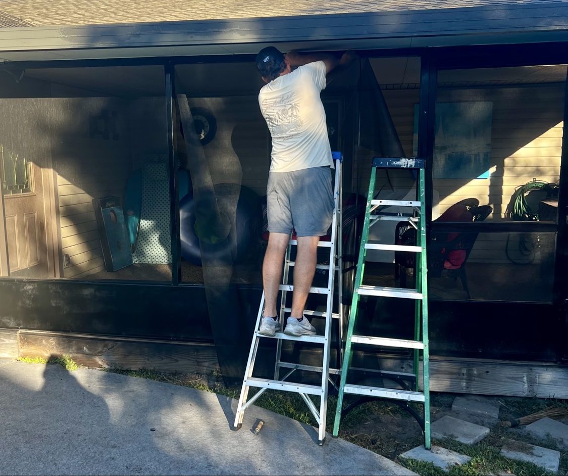 Pelican Pool and Patio technician on a ladder rolling new screen panels into the enclosure frame